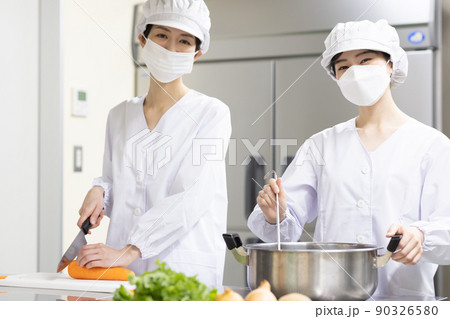 白衣を着て食事を作る女性 90326580