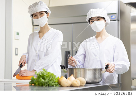 白衣を着て食事を作る女性 90326582