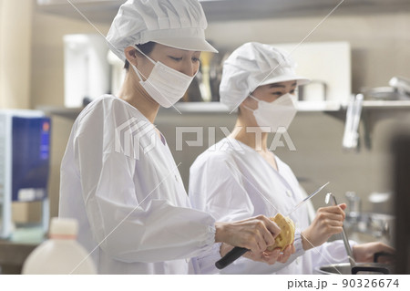 白衣を着て食事を作る女性 90326674