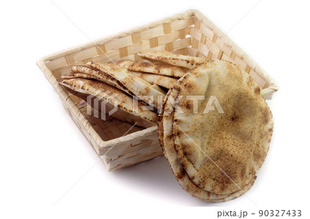 Pita bread isolated on white background in the breakfast basket. Traditional food of Arabic cuisine Pita bread isolated on white background in the breakfast basket. Traditional food of Arabic cuisine 90327433