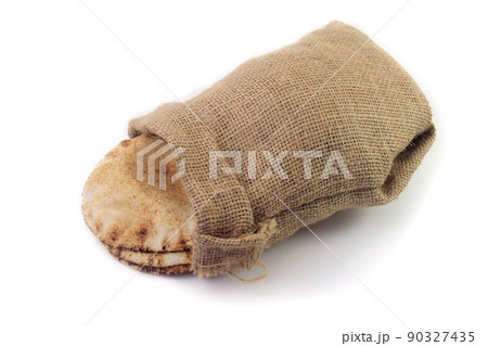 Pita bread isolated on white background of rustic fabric bag. Food of Arab cuisine Pita bread isolated on white background of rustic fabric bag. Food of Arab cuisine 90327435
