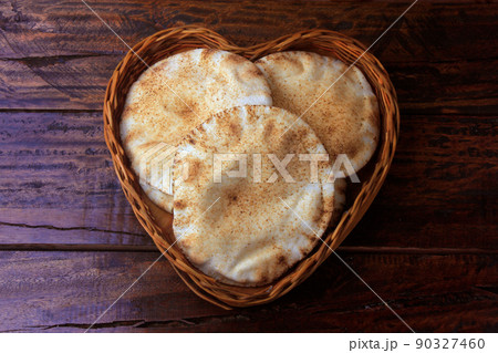 Pita bread isolated on white background in the breakfast basket, on rustic wooden table.Traditional food of Arabic cuisine Pita bread isolated on white background in the breakfast basket, on rustic wooden table.Traditional food of Arabic cuisine 90327460