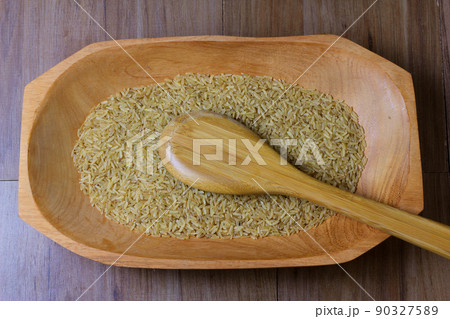 portion of raw brown rice, wooden bowl, wooden table top view portion of raw brown rice, wooden bowl, wooden table top view 90327589
