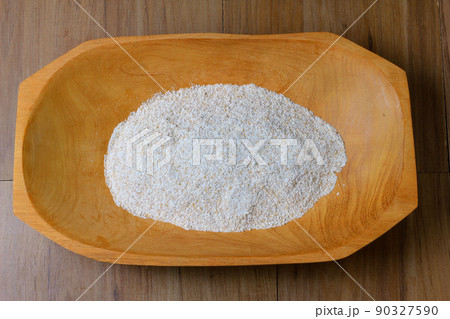 portion of raw whole wheat flour, wooden bowl, wooden table top view portion of raw whole wheat flour, wooden bowl, wooden table top view 90327590