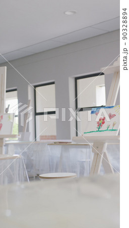 Vertical image of empty white painting classroom with painting equipment and easel 90328894
