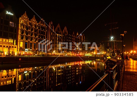 Old town in Gdansk at night. The riverside on Granary Island reflection in Moltawa River Cityscape at twilight. Ancient crane at dusk. Visit Gdansk Poland Travel destination 90334585