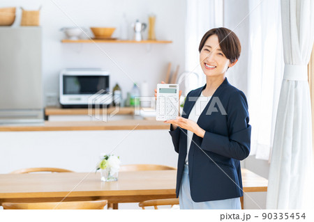 電卓を持つ不動産業のミドルのビジネスウーマン 電卓を持つ不動産業のミドルのビジネスウーマン 90335454