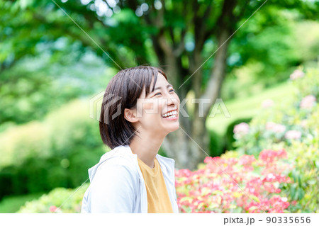 新緑の公園でリフレッシュする若い女性 90335656