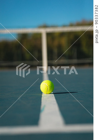 Surface level view of green ball on white line at empty court during sunny day 90337382