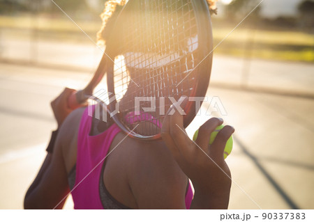 African american young female player with racket behind head at court 90337383