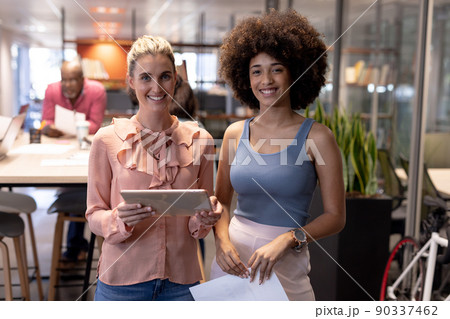 Portrait of smiling multiracial businesswomen working together at modern workplace Portrait of smiling multiracial businesswomen working together at modern workplace 90337462