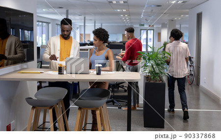 Young african american business advisors working together while standing with laptop at workplace Young african american business advisors working together while standing with laptop at workplace 90337868