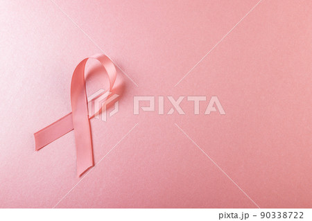 Directly above shot of pink breast cancer awareness ribbon against pink background, copy space Directly above shot of pink breast cancer awareness ribbon against pink background, copy space 90338722