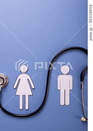 Directly above shot of paper couple with stethoscope against blue background, copy space 90338958