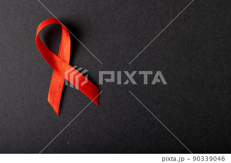 Directly above shot of aids awareness red ribbon isolated against black background, copy space 90339046