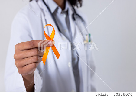 Midsection of african american mid adult female doctor with yellow sarcoma cancer awareness ribbon 90339070
