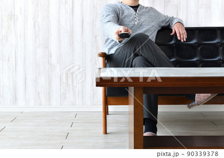 テレビのチャンネルを変える男性 90339378