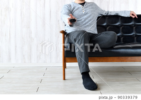 テレビのチャンネルを変える男性 90339379