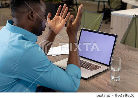 African american businessman on video call through laptop with copy space on screen at desk 90339920