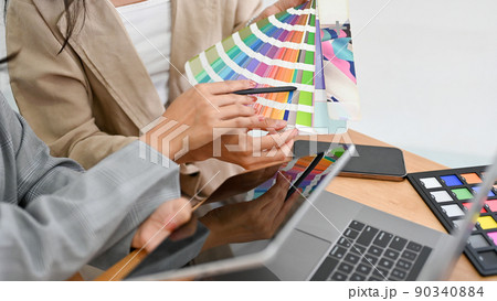 Two of a graphic designers are discussing and planning the web colour for their project together. Two of a graphic designers are discussing and planning the web colour for their project together. 90340884