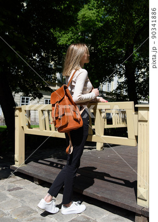 photo of a woman with a orange leather backpack with antique and retro look. Outdoors photo photo of a woman with a orange leather backpack with antique and retro look. Outdoors photo 90341886