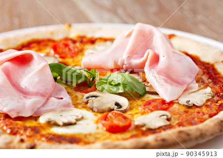 Pizza with mushrooms, ham, and fresh basil. Pizza with mushrooms, ham, and fresh basil. 90345913