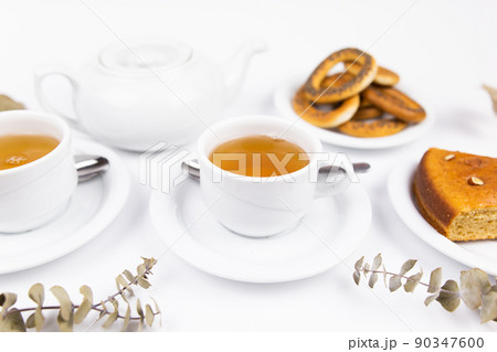 white tea set with teapot tea and saucers and pie for breakfast 90347600