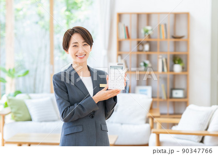 電卓を持つ不動産業のビジネスウーマン 電卓を持つ不動産業のビジネスウーマン 90347766