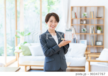電卓を持つ不動産業のビジネスウーマン 90347767