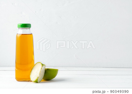 Glass bottle of apple juice with apple fruit on white background Glass bottle of apple juice with apple fruit on white background 90349390