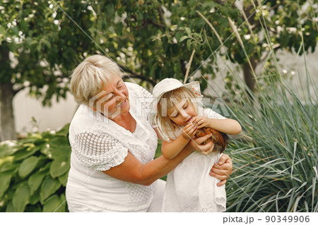 Family in a back yeard. Granddaughter with grandmother. People with little chicken. Family in a back yeard. Granddaughter with grandmother. People with little chicken. 90349906