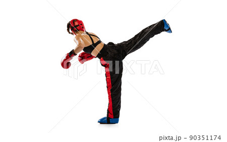 High kick. One female boxer in boxing gloves and helmet training isolated on white studio background. Sport, competition, hobby, results, success concept High kick. One female boxer in boxing gloves and helmet training isolated on white studio background. Sport, competition, hobby, results, success concept 90351174