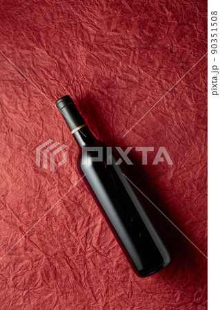 Bottle of red wine on a crumpled red paper background. Bottle of red wine on a crumpled red paper background. 90351508