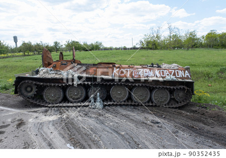 A burnt Russian tank near a residential building. War in Ukraine 2022. Russian missiles in Kharkiv countryside Ukraine. Russian aggression, conflict. Russian attack on Ukraine. Russia is bombing Ukrai A burnt Russian tank near a residential building. War in Ukraine 2022. Russian missiles in Kharkiv countryside Ukraine. Russian aggression, conflict. Russian attack on Ukraine. Russia is bombing Ukrai 90352435