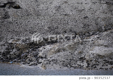 泥だらけで草もない溜池の中に流れている川 泥だらけで草もない溜池の中に流れている川 90352537