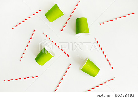Green paper cups with striped paper straw flat lay on white background. Eco-friendly concept 90353493