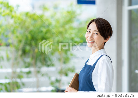 カフェの前でお客様を迎えるミドル女性 カフェの前でお客様を迎えるミドル女性 90353578