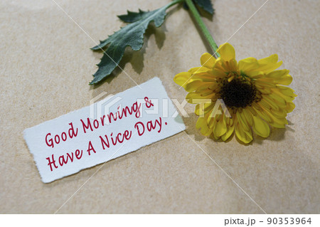 Motivational quote on torn white paper on wooden surface with sunflowers. 90353964