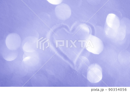 Hand-drawn heart on snowy surface with warm glittering bokeh background, toned very peri 90354056