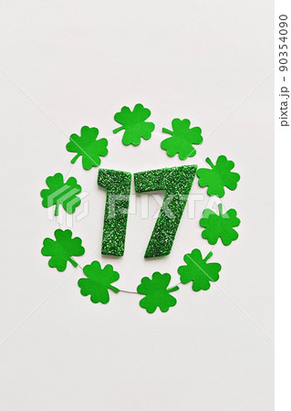 Numeral 17 on white background with round frame of paper-cut four-leaf clover leaves Numeral 17 on white background with round frame of paper-cut four-leaf clover leaves 90354090