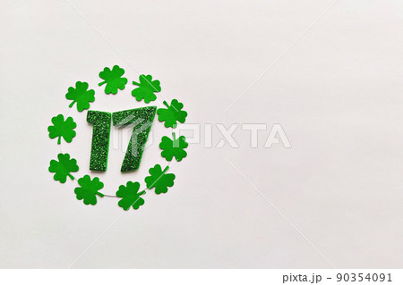 Numeral 17 on white background with round frame of paper-cut four-leaf clover leaves Numeral 17 on white background with round frame of paper-cut four-leaf clover leaves 90354091