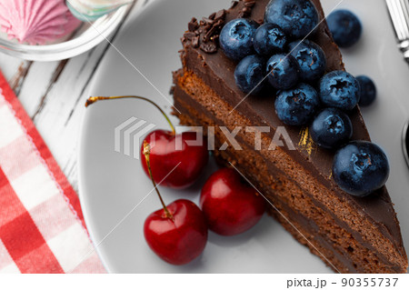 Piece of chocolate cake served with fresh berries 90355737
