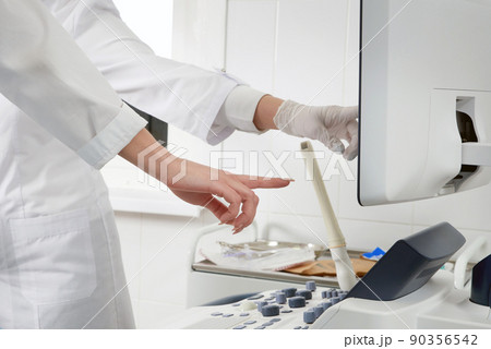 Gynecologist ready to do transvaginal ultrasound with wand and exam a woman 90356542