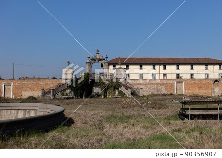 facade of an ancient castle with large windows in italy 90356907