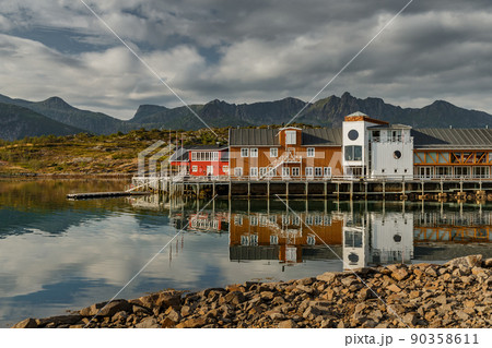 a classical building for stopping yacht travellers, fishing house of red color on the coast on Lofoten Islands, classic norwegian landscape, rocky coast with dramatic sky a classical building for stopping yacht travellers, fishing house of red color on the coast on Lofoten Islands, classic norwegian landscape, rocky coast with dramatic sky 90358611