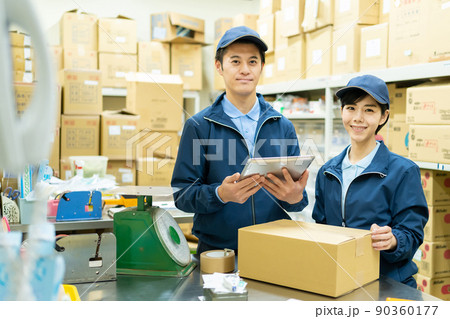 倉庫で梱包作業をする女性と男性スタッフ 90360177