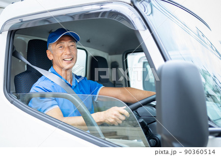 トラックを運転するミドルの男性ドライバー 90360514