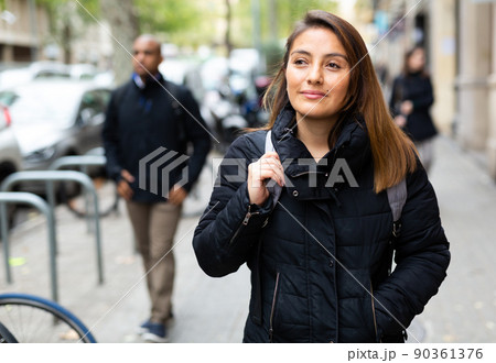 Smiling woman walking outdoors at cold day Smiling woman walking outdoors at cold day 90361376