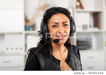 Friendly female call center operator receiving calls in office Friendly female call center operator receiving calls in office 90361438