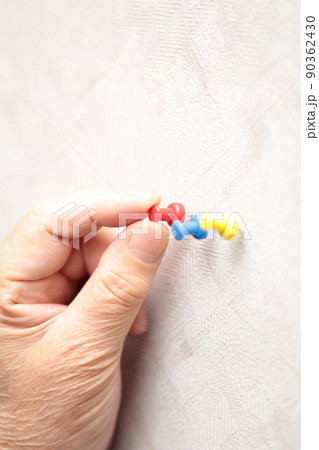 画鋲を刺すシニア女性の指 90362430